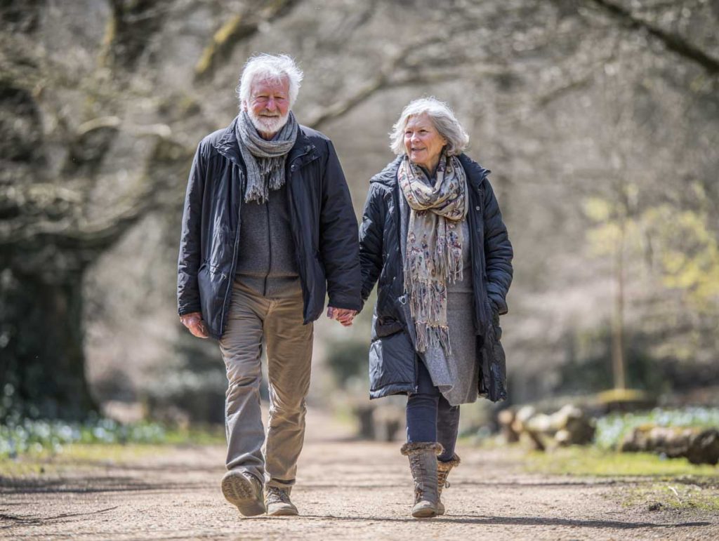 A mature couple walking in the woods