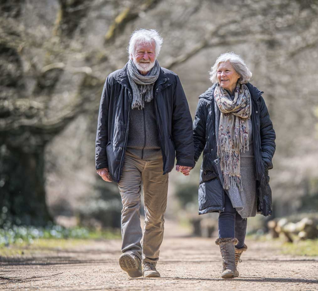 A mature couple walking in the woods